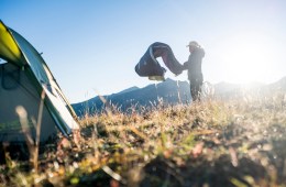 A camper shakes out their sleeping bag.