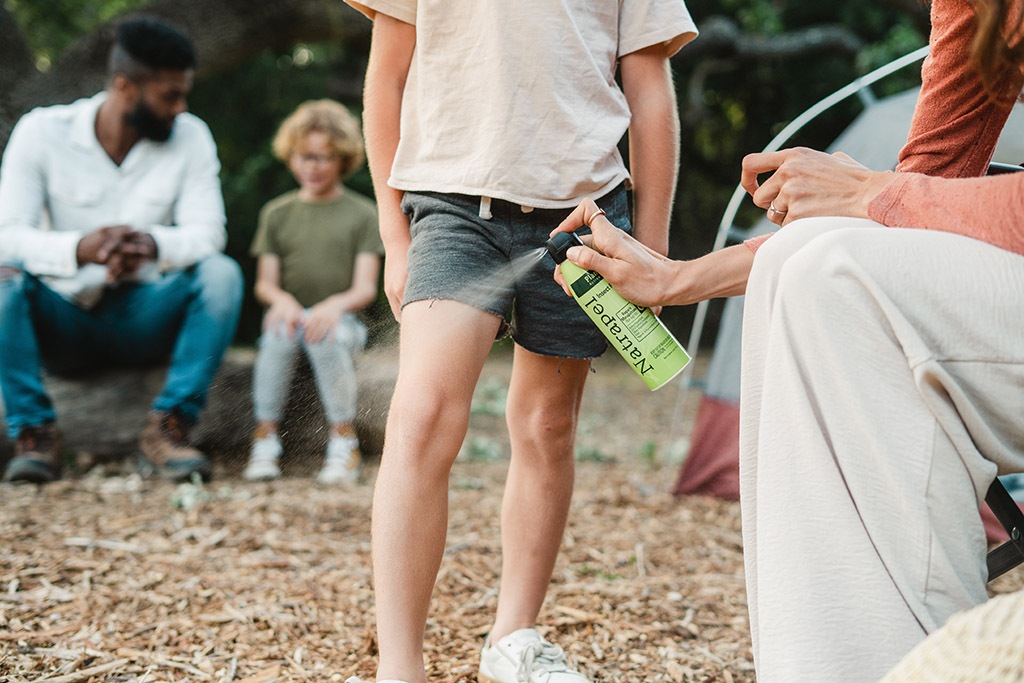 A child is sprayed with natural insect repellenet.