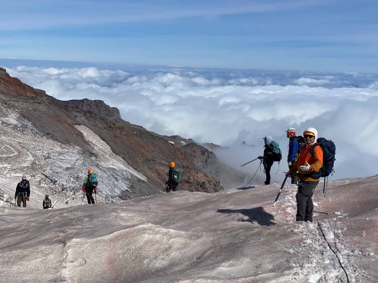 A group of mountaineers at high elevation, above the cloud line.
