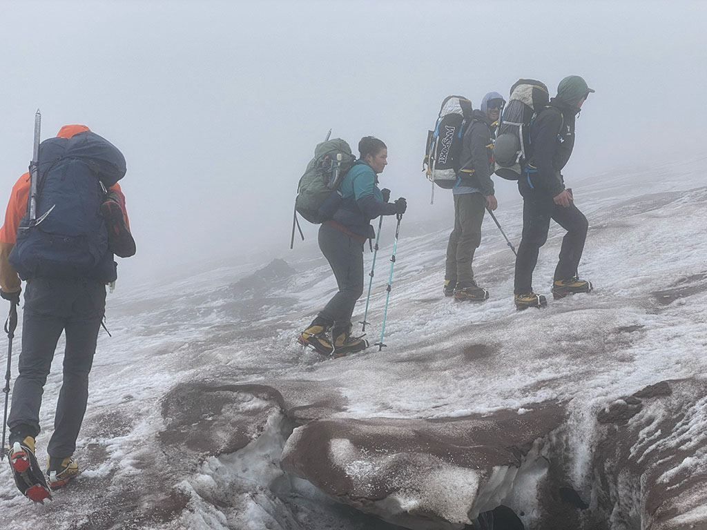 A group of climbers encounter misty conditions while scaling a mountain