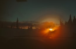 A bright sunset peeking over mountains