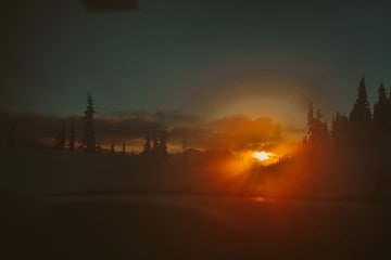 A bright sunset peeking over mountains