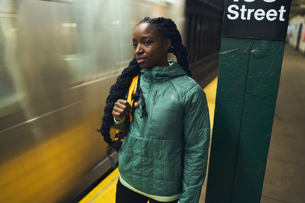 A person wearing a Circaloft hoodie waits for a subway train.