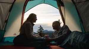 Two people chat inside a tent.