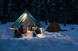 Picture of people camping in the snow at night.