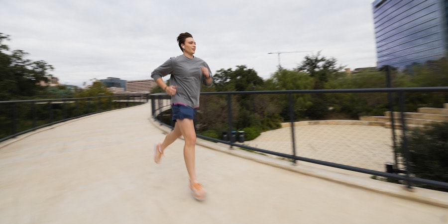 A runner traversing a city promenade in the REI Co-op Active Pursuits 6