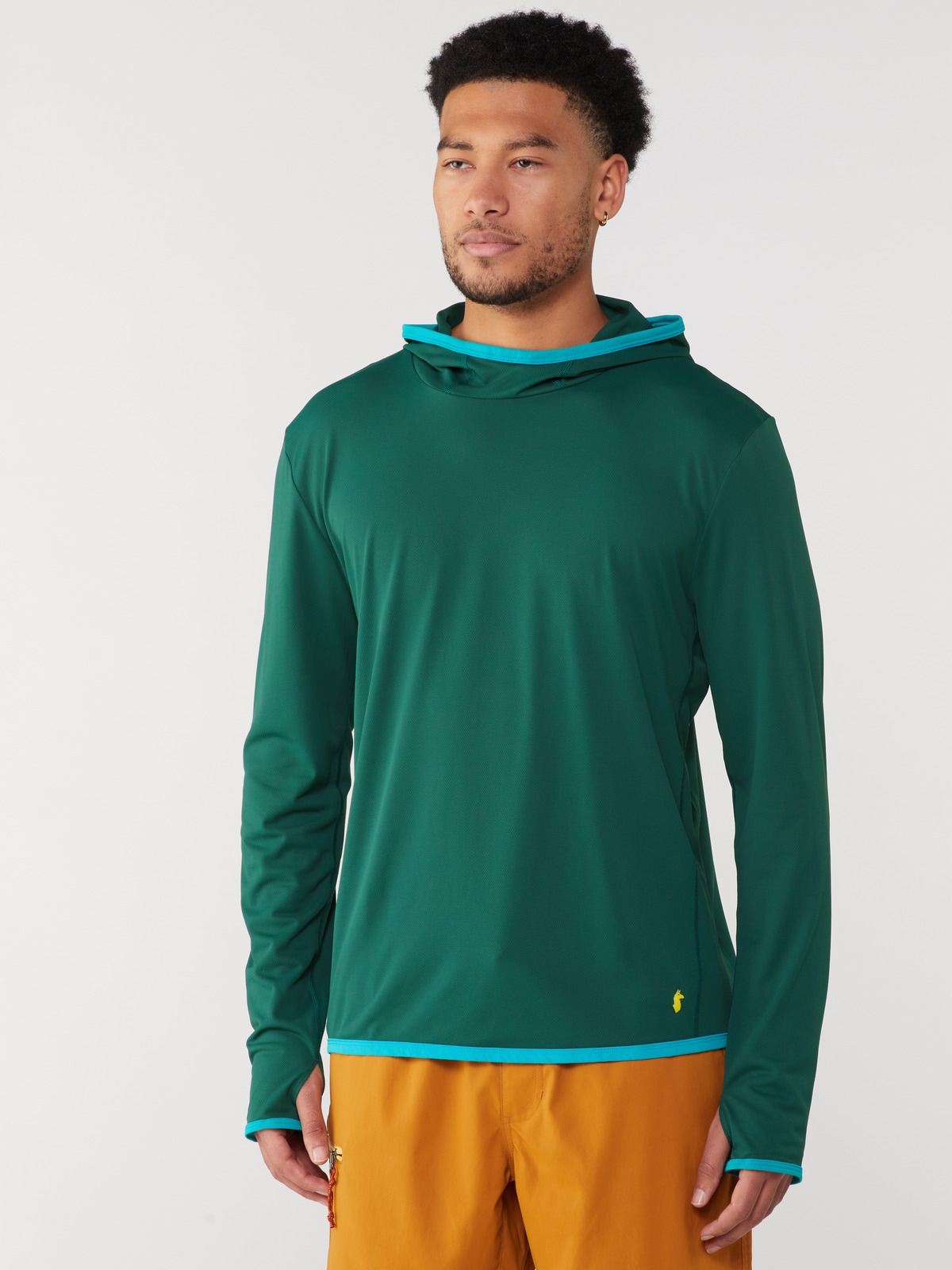 A person wearing a green Cotopaxi sun hoodie with blue trim.