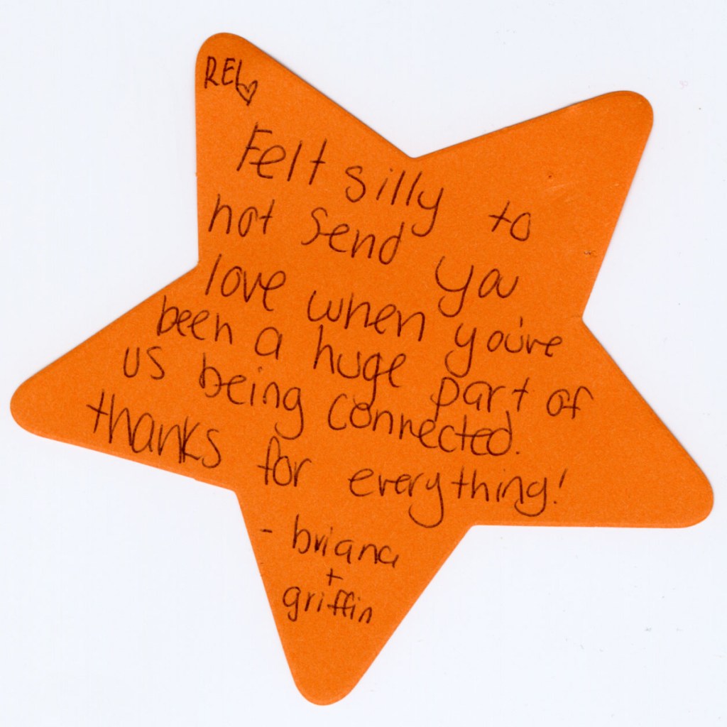 A handwritten note on a piece of orange, star-shaped paper