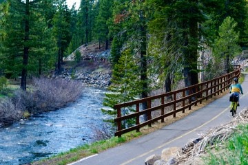 A person bikes along a scenic bike and pedestrian path in North Lake Tahoe.