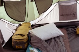 A sleeping bag and pillow inside a tent at camp.