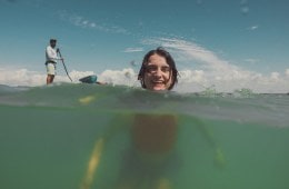 A swimmer is shown halfway submerged underwater, with their head above the surface.