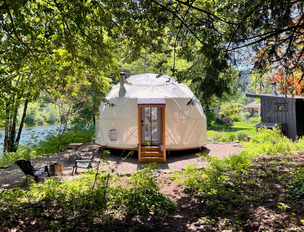 Photo of a geodesic dome in the woods.