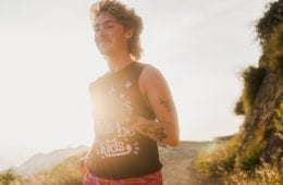 Endurance athlete and activist Cal Dobs running in pink shorts and a black shirt that says "Let trans kids be kids"