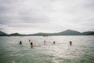 Photo of six people swimming in a body of water.