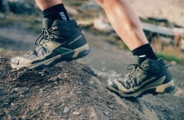 A close-up of a person's boots as they scale a boulder.