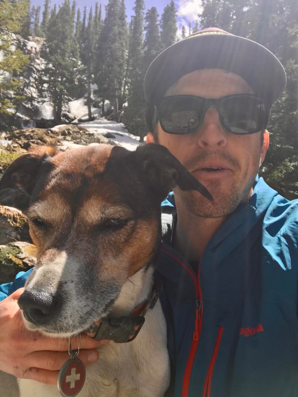 A person takes a selfie with their dog on the trail.