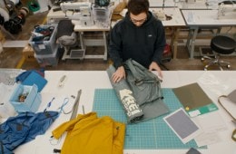 A designer rolls out a tent on a table