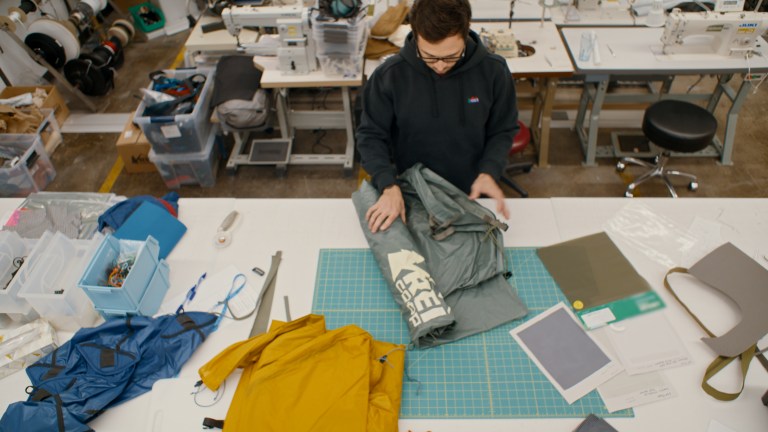 A designer rolls out a tent on a table
