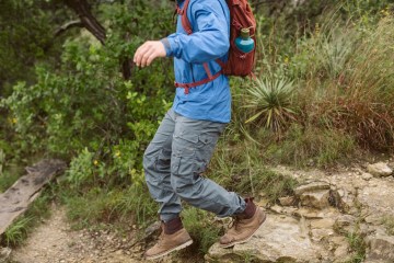 A solo hiker bounds down a rocky trail.