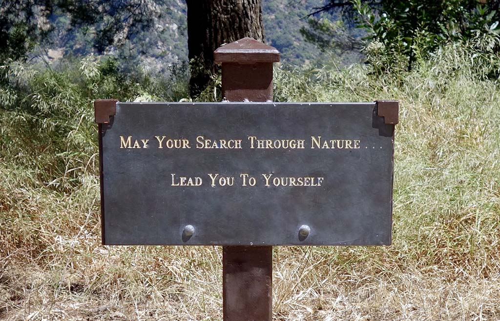 A trail sign that reads "May your search through nature… lead you to yourself."