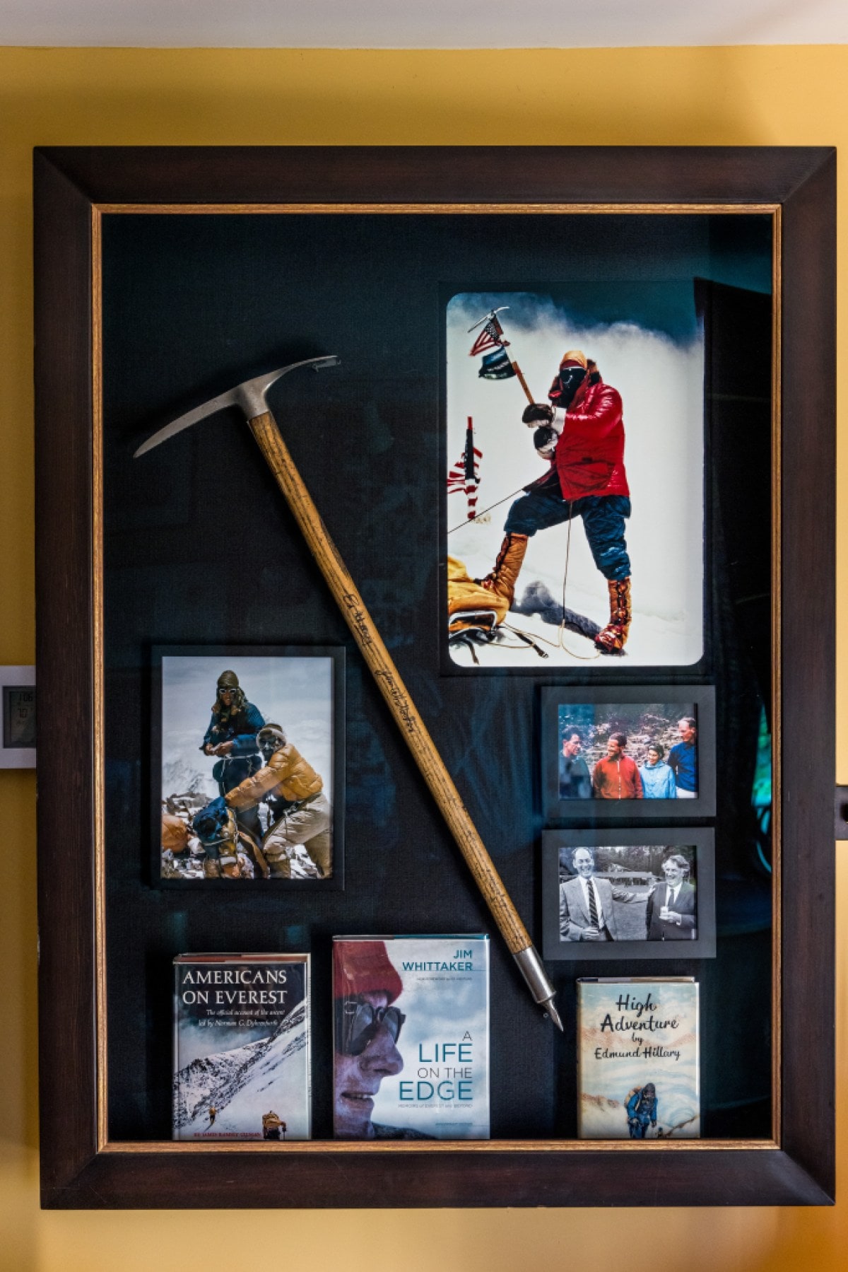 A collection of photographs of Whittaker's climbs including the icon shot of him waving a flag on the top of Everest