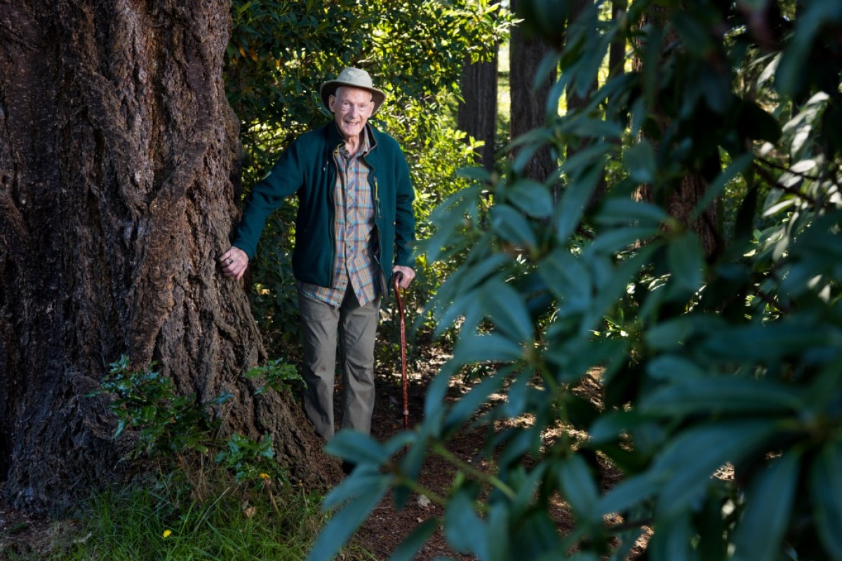 Jim Whittaker stands amid tall trees near his home in Washington state
