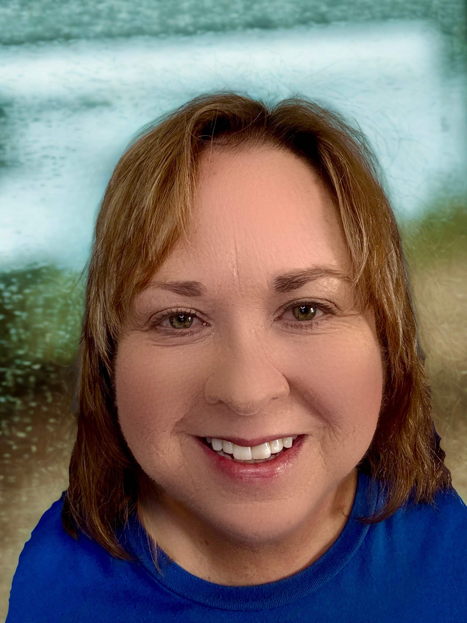 A close-up of a person in a blue shirt smiling at the camera