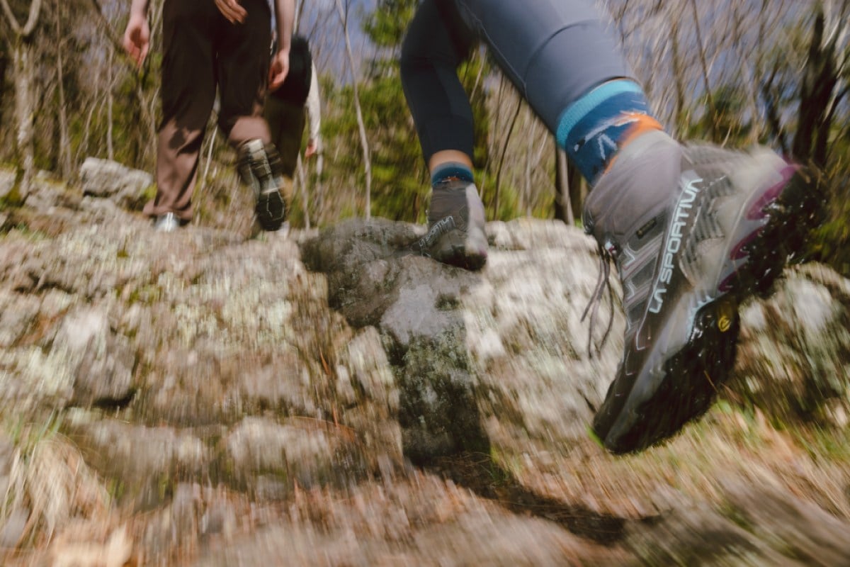 A close-up of a person's feet in boots as they charge up a rocky outcropping.