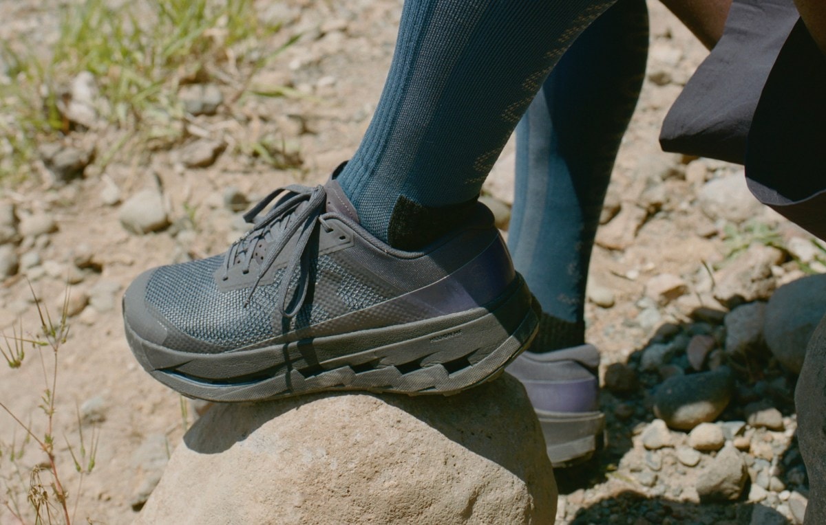 A close up of a trail-running shoe on a rock.
