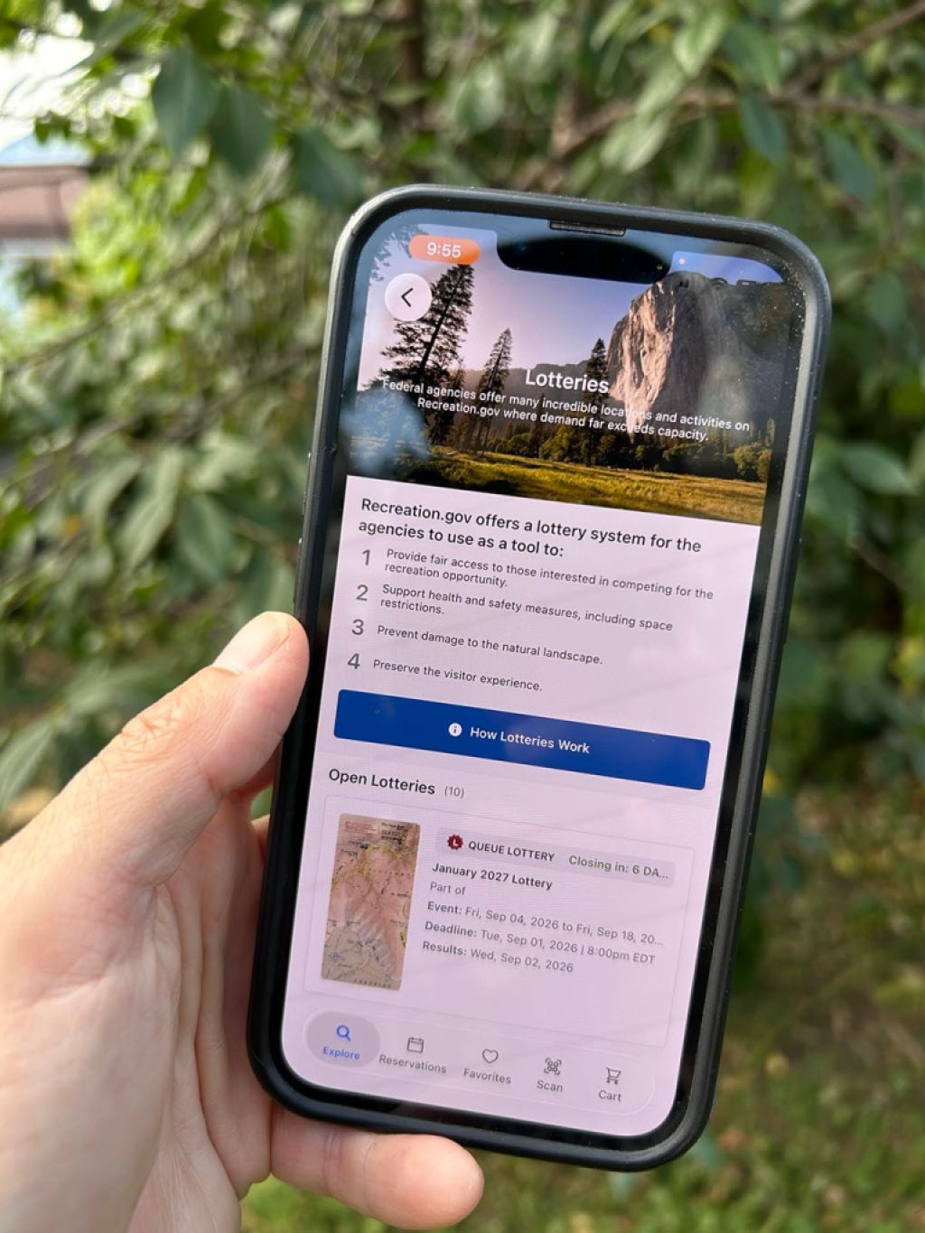 A person holds a phone with the screen displaying the permit lottery on the Recreation.gov app.