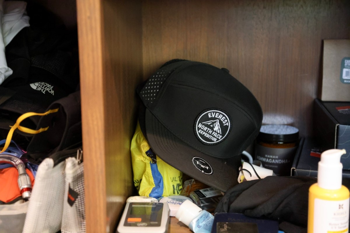 A shelf in a gear closet with a hat and various other pieces of gear.