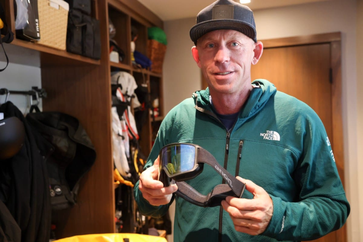 Jim Morrison holds a pair of ski goggles in his gear closet.