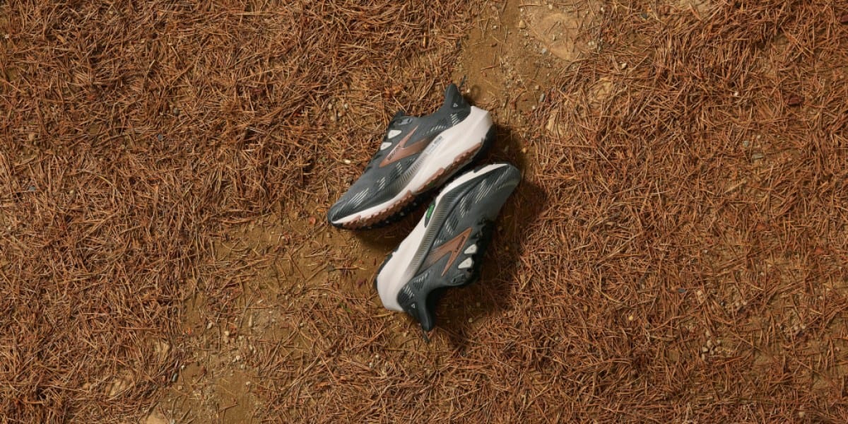 A pair of Brooks Ghost Trail Trail-Running shoes lying on a dirt path