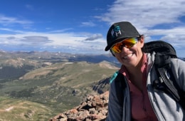 Courtney Conley smiling on a mountain during a hike.