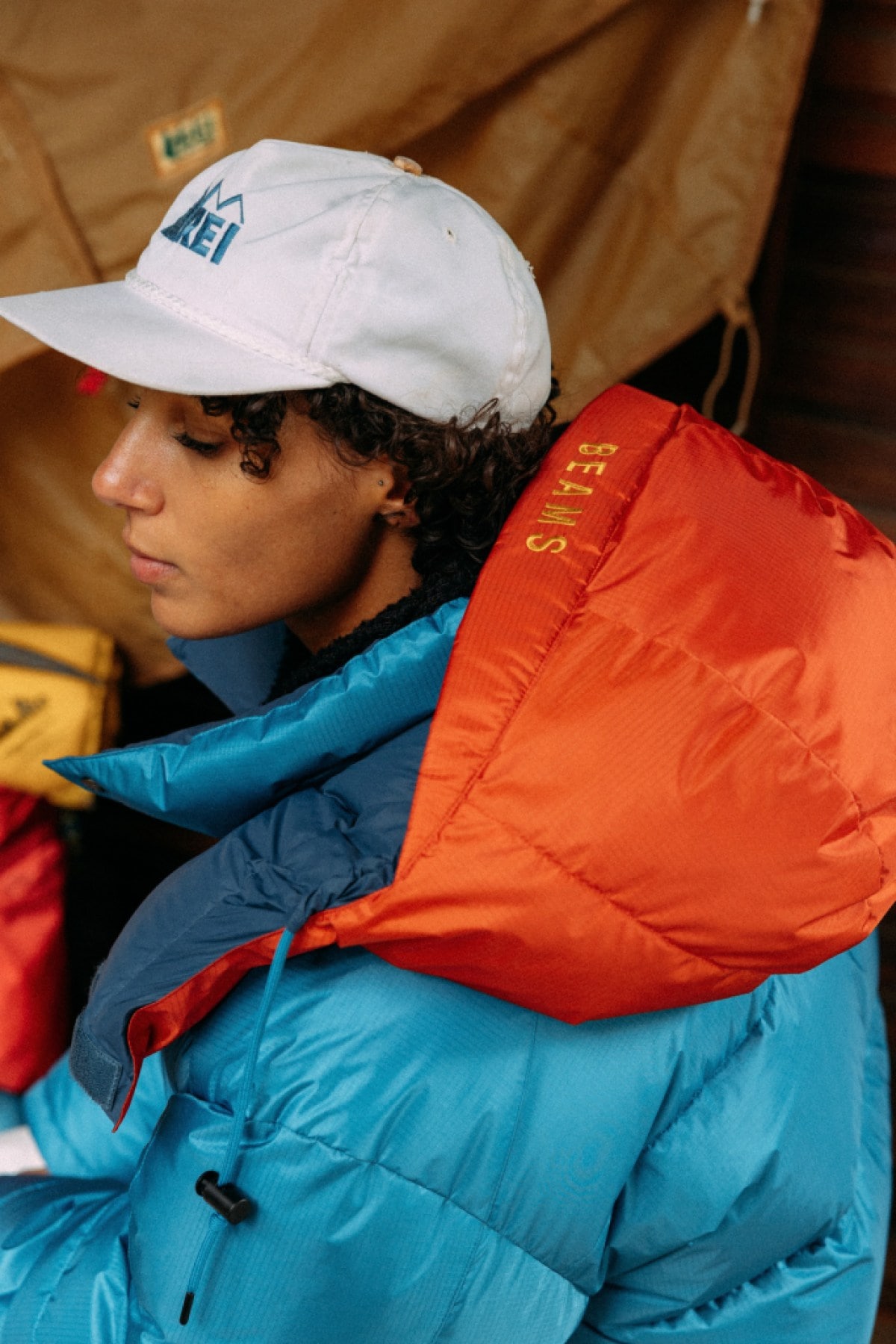 A person wears a bright blue down parka with a bright red hood. Photo Credit: Marissa Alves for REI