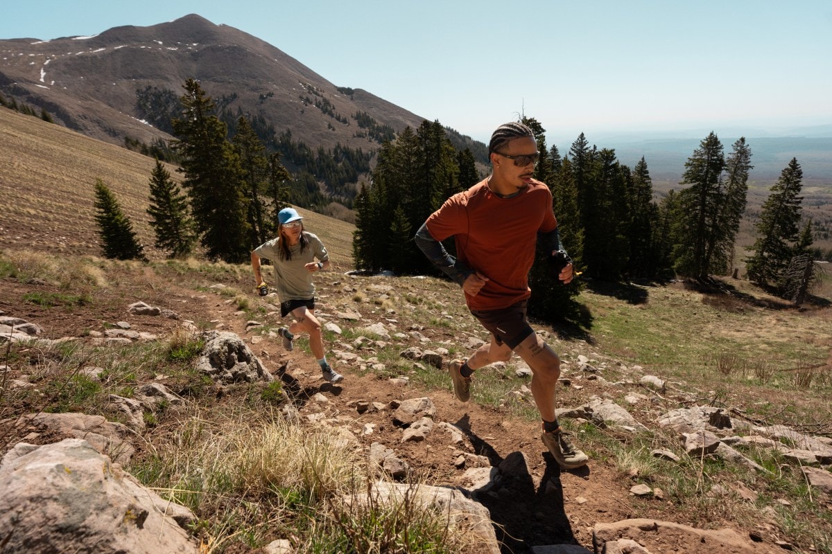 Two people running up a mountain