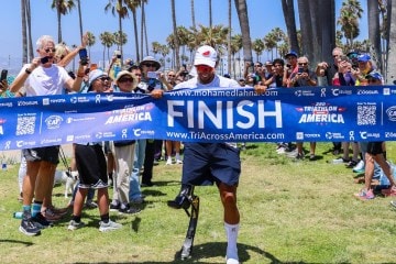 Mohamed Lahna running through a finish line ribbon. For REI's Wild Ideas Worth Living podcast.