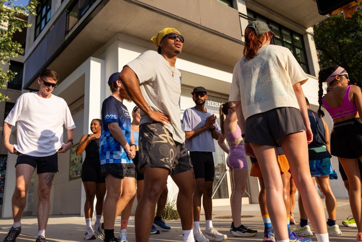 A group of runners standing on a street corner