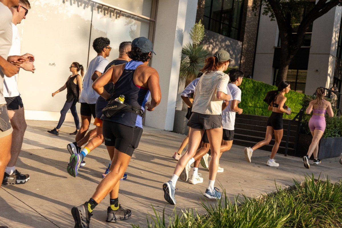 A group of people running on a sidewalk