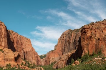 A photo of red rock formations against a blue sky with some wispy clouds