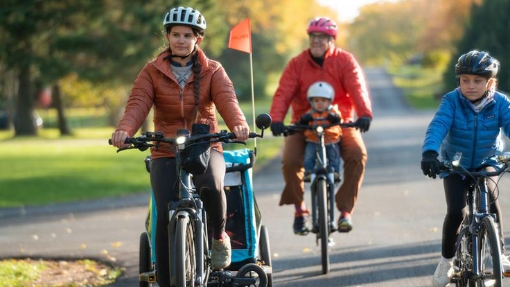 Three children and one adult riding bikes