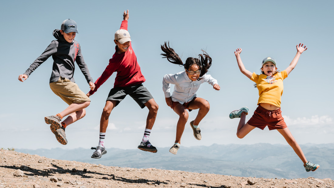 Kids jumping into the air at Yellowstone National Park.