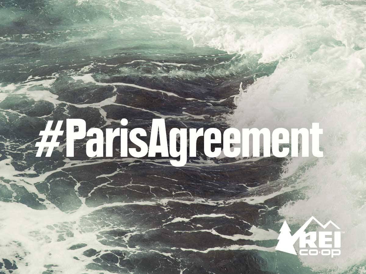 Paris climage agreement hashtag on breaking ocean waves.