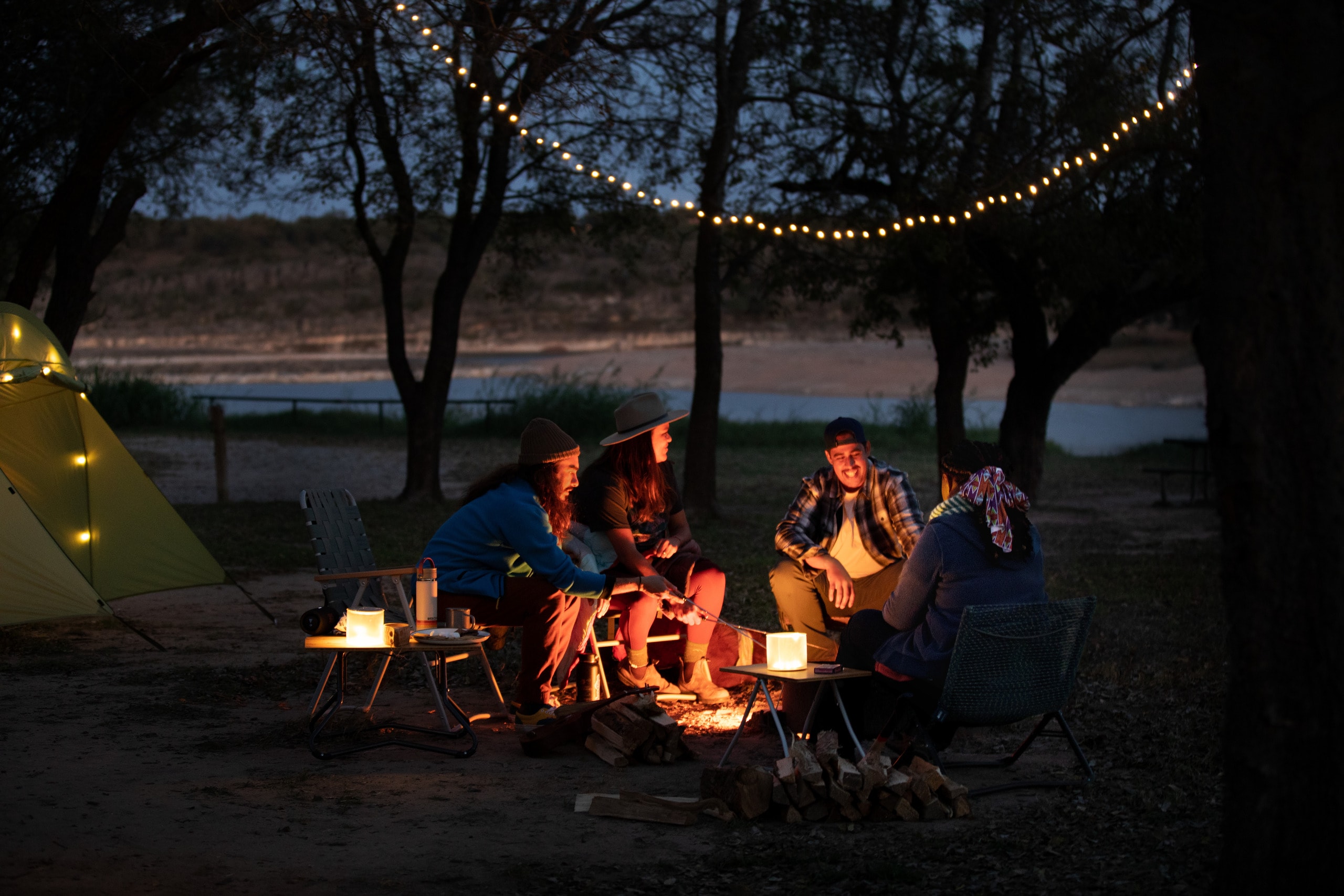 Four campers sit around a bonfire at night