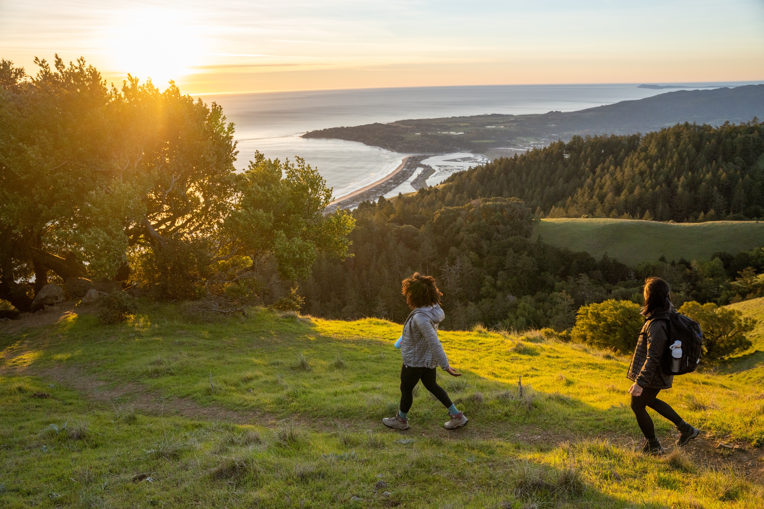 Two hikers follow a path along a shoreline trail