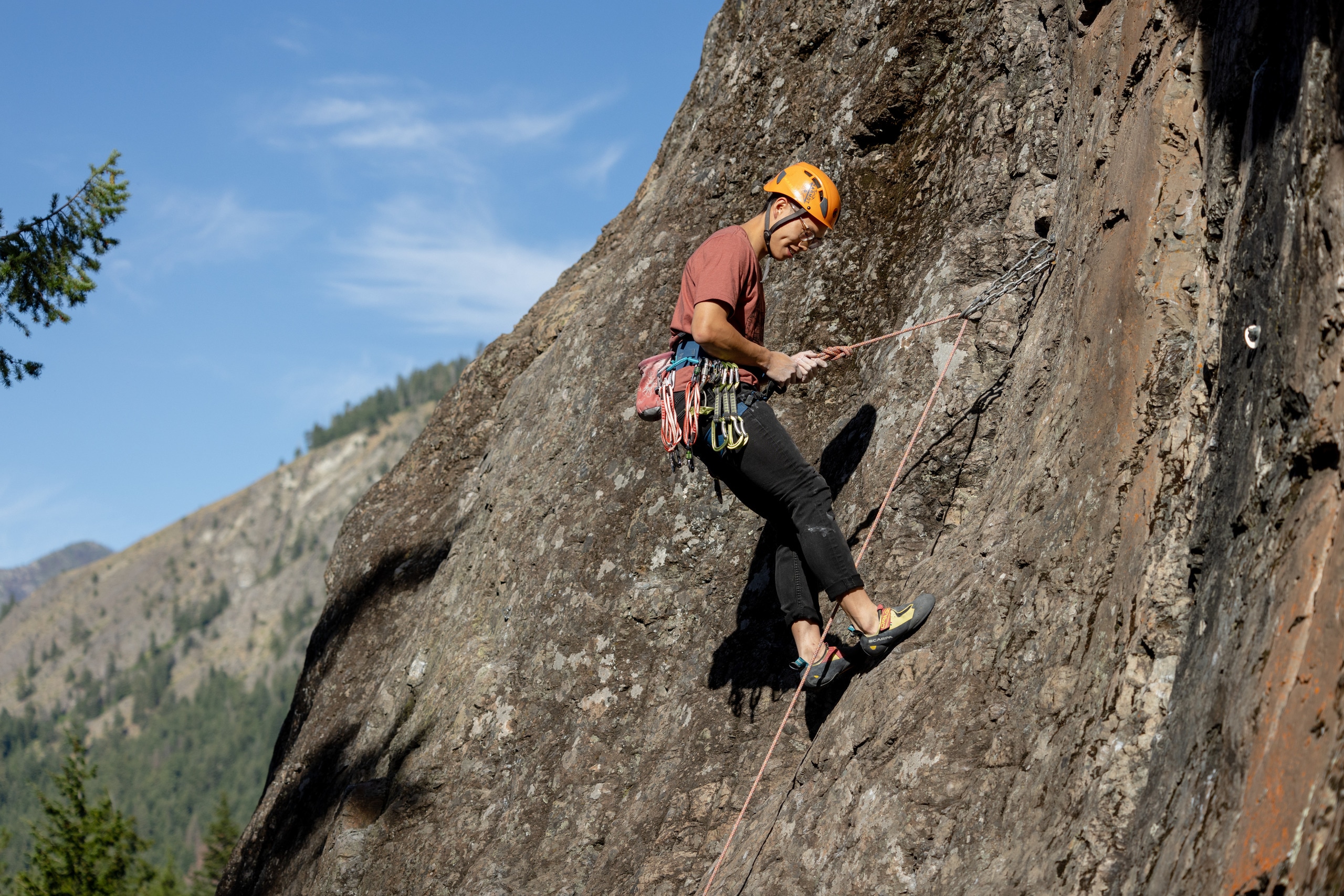 A climber rapels down a rock face