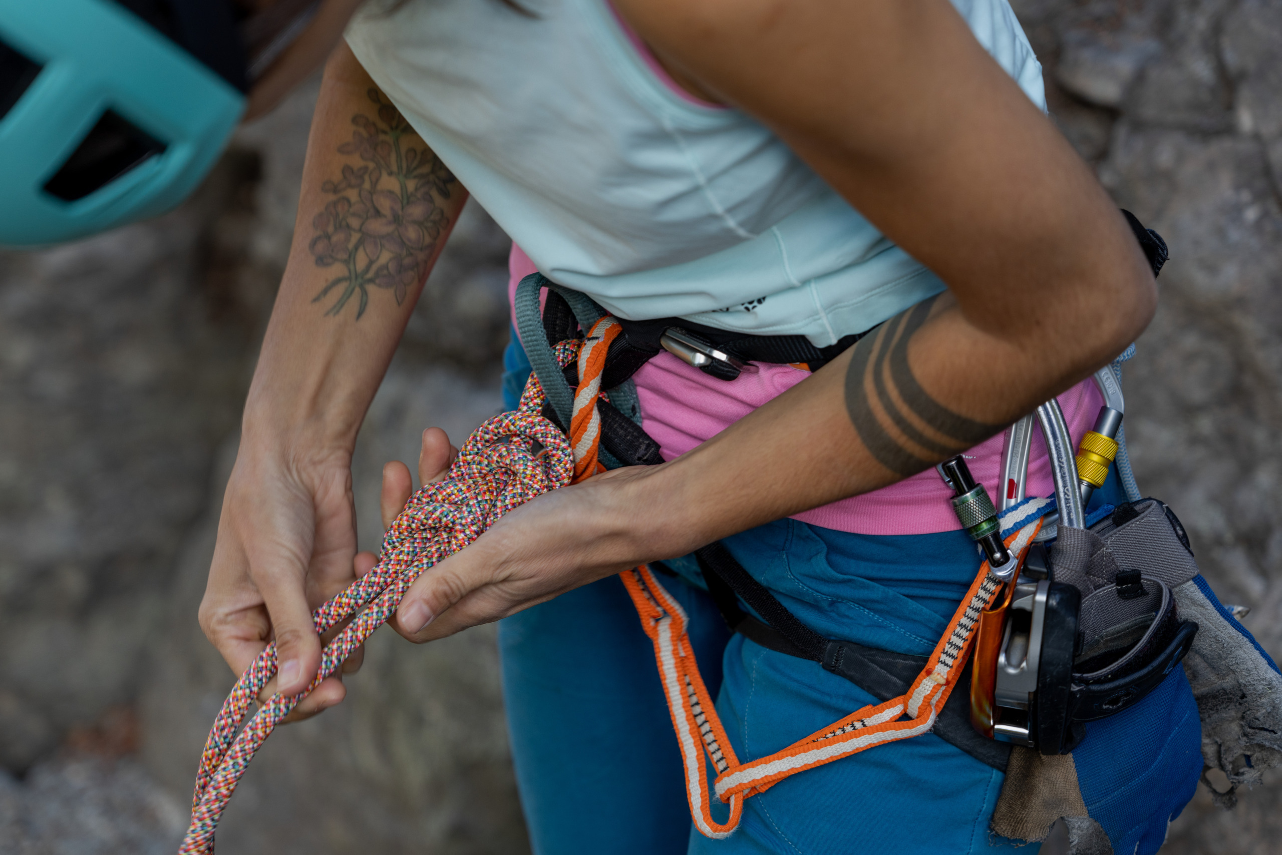 A climber ties a figure-eight knot to attach a climbing rope to their climbing harness