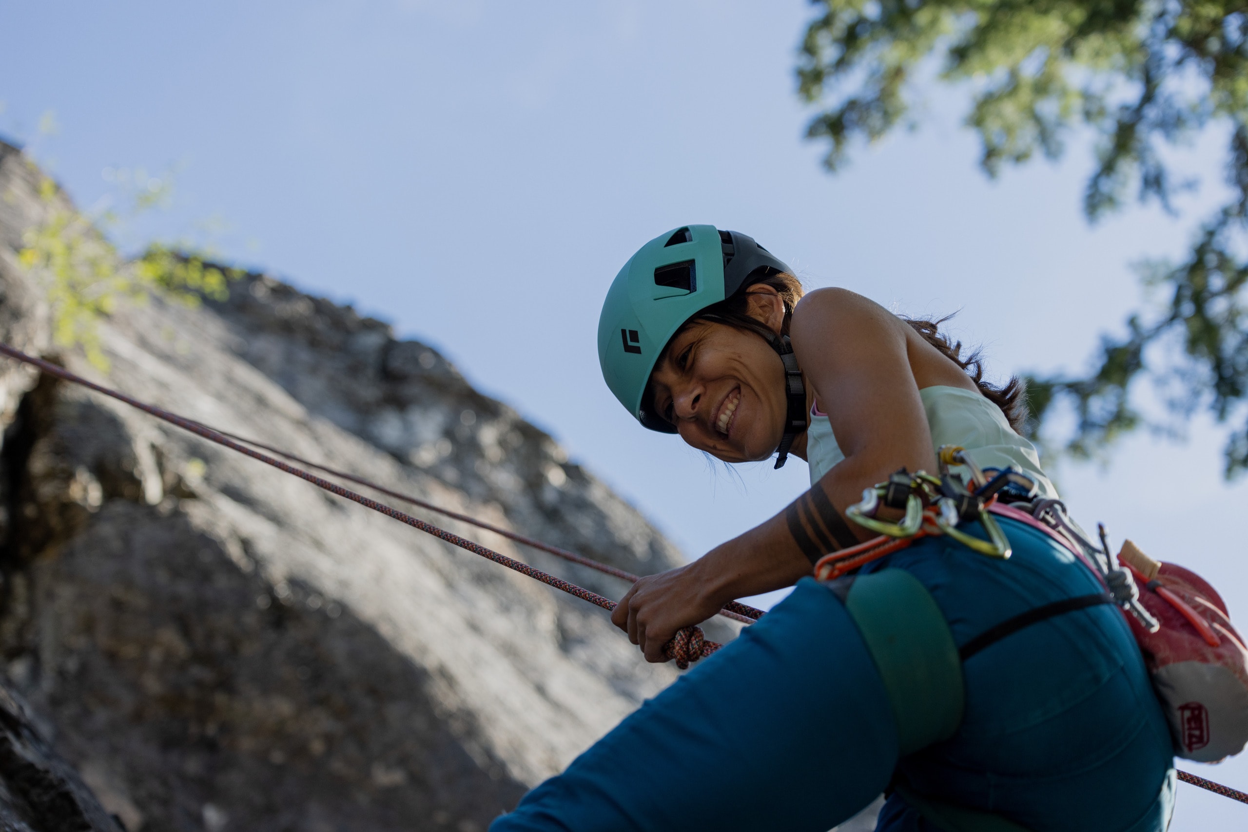 A rock climber rappels off a rock wall