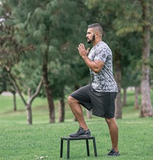 Goal_BCS_Step_Ups_A Starting a step up exercise on a stool in a park