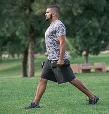 Goal_BCS_Weight_Lunge_A Starting a weighted lunge exercise in a park